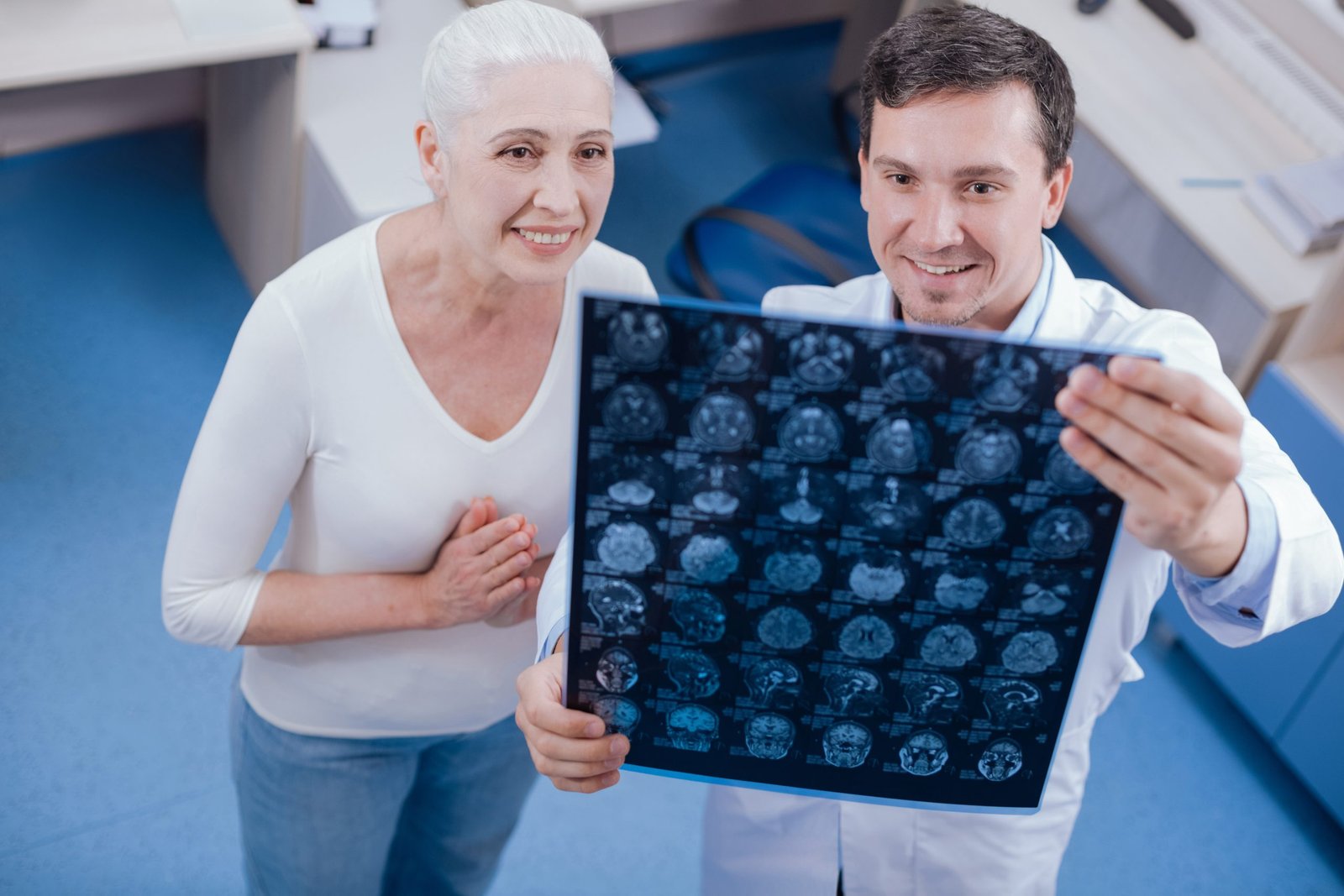cheerful nice elderly woman looking x ray photo being relieved while having no physical deviations scaled
