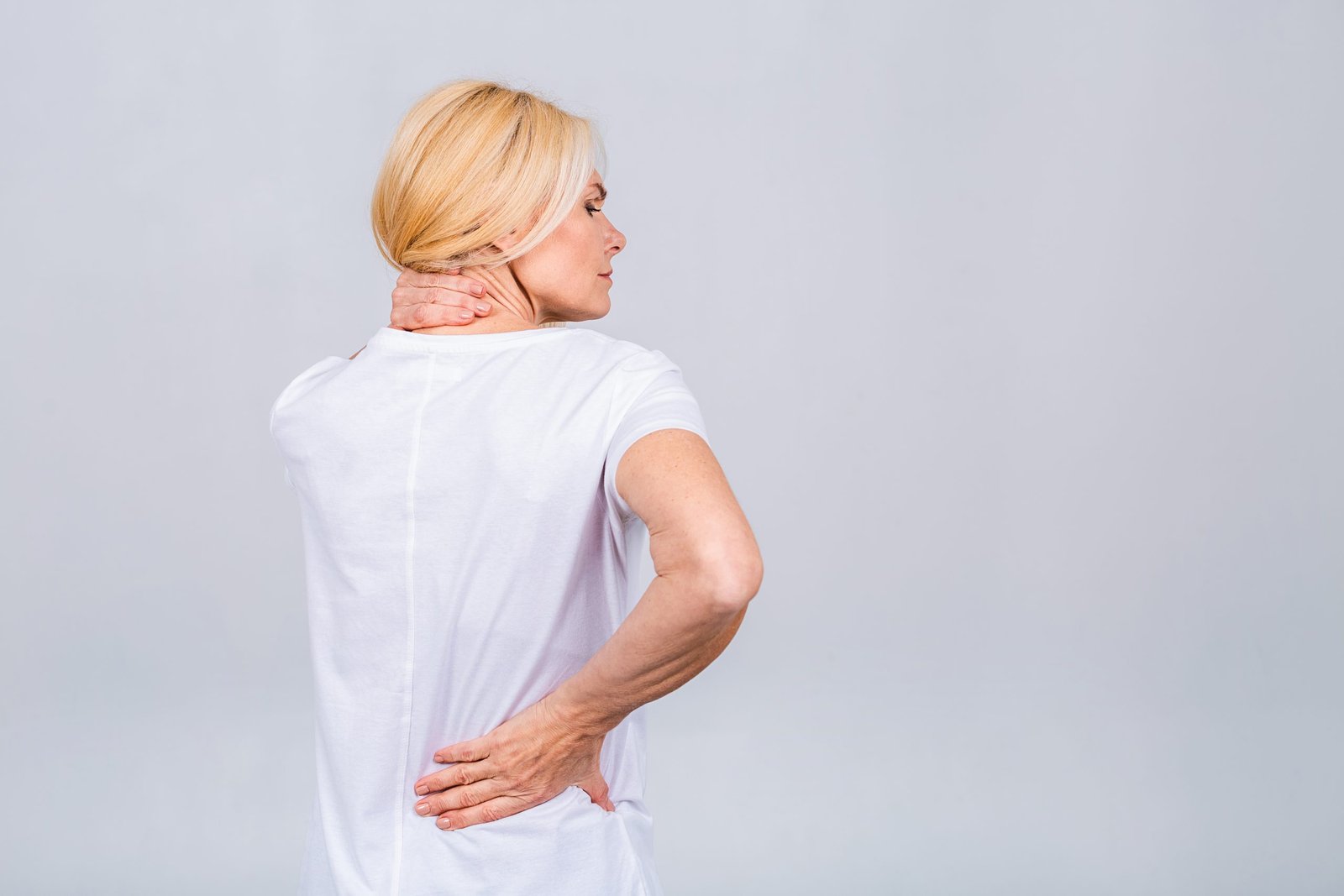mature senior old beautiful woman wearing casual suffering from back pain empty blank copy space with backache concept isolated white grey background scaled